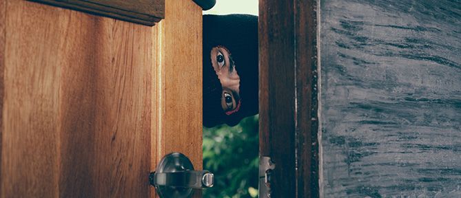 man in mask peeping through door