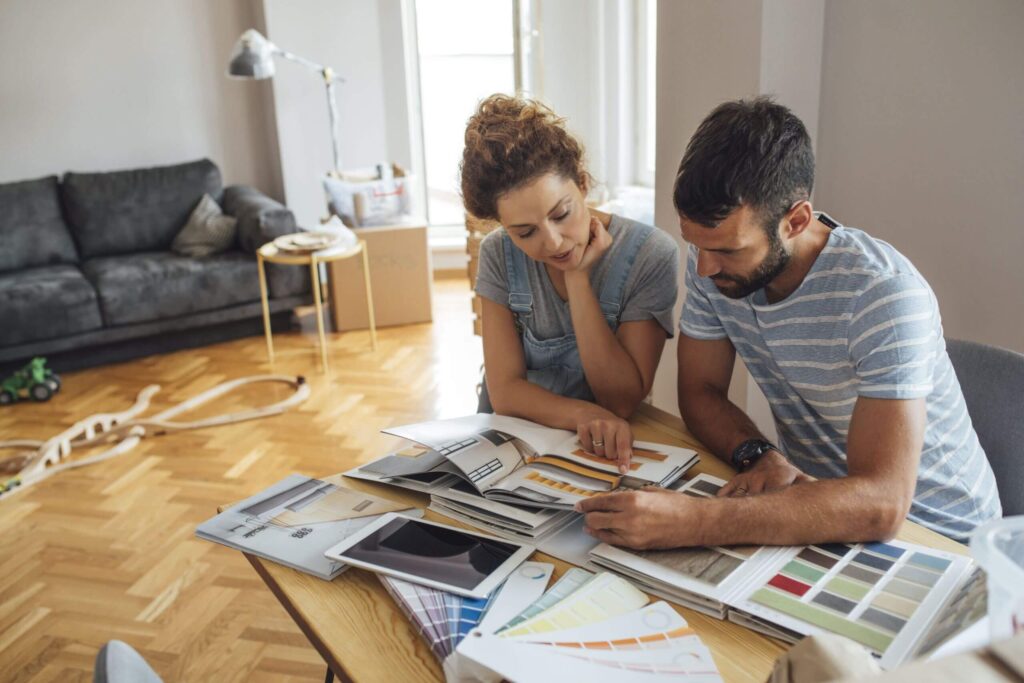 couple looking at books for interior design options